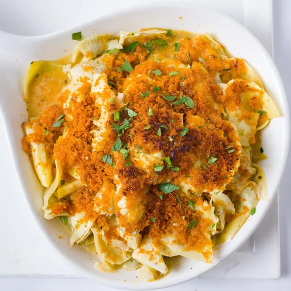 Davinci's baked pasta dish with golden breadcrumbs and fresh parsley in a white bowl.