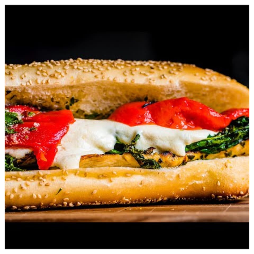 Davinci's Italian sub with melted cheese, red peppers, and greens on a sesame seed roll.